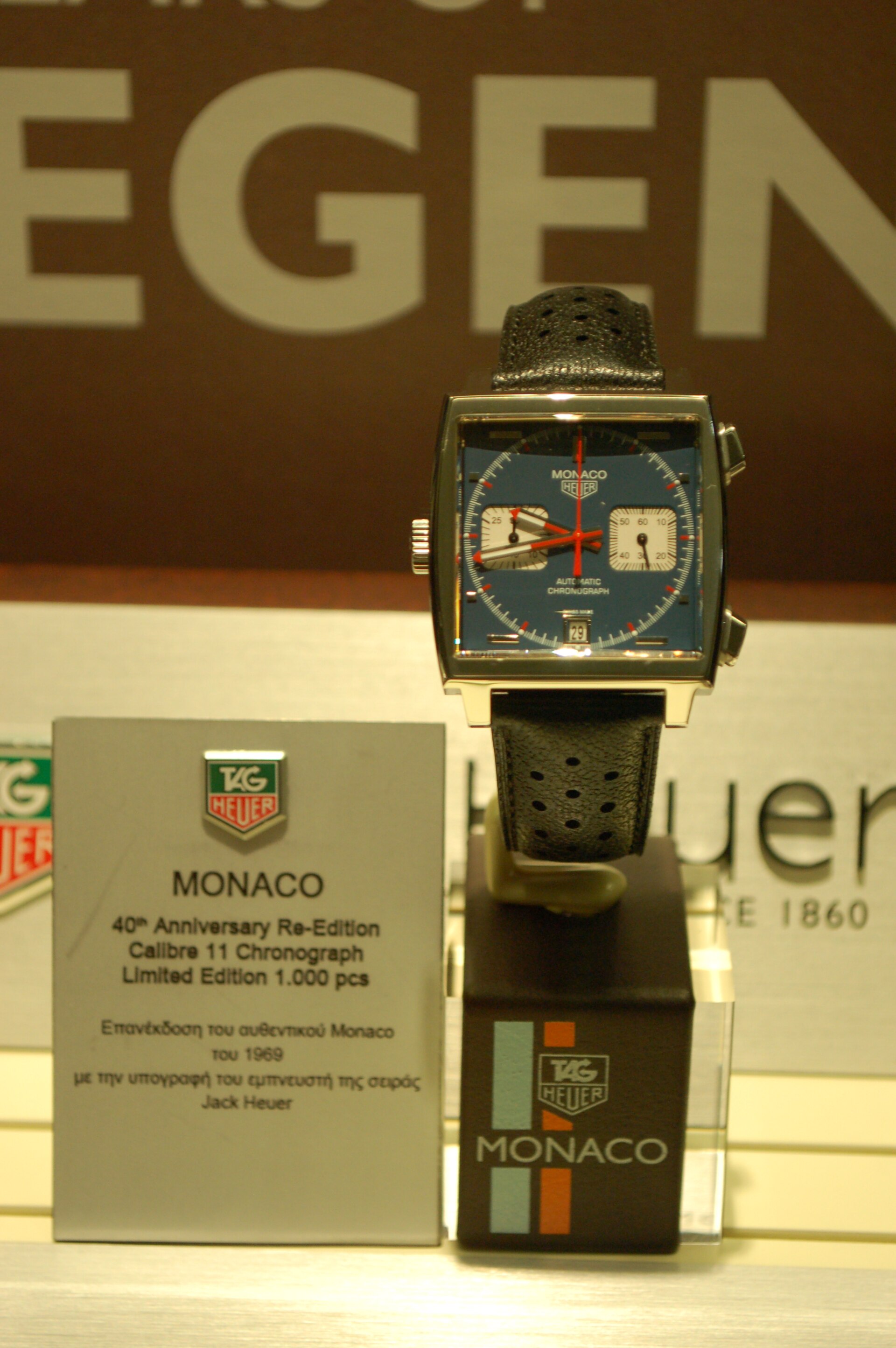 A blue-dial TAG Heuer Monaco 40th anniversary re-edition with a left-hand crown displayed on a shop stand