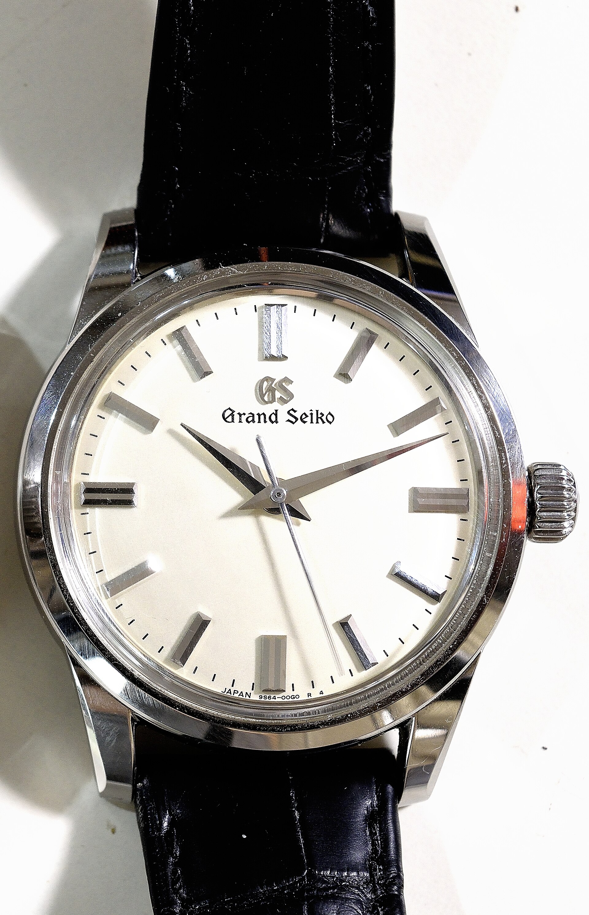 A hand-wound Grand Seiko dress watch with a cream dial and the Grand Seiko name alone at twelve on a black leather strap