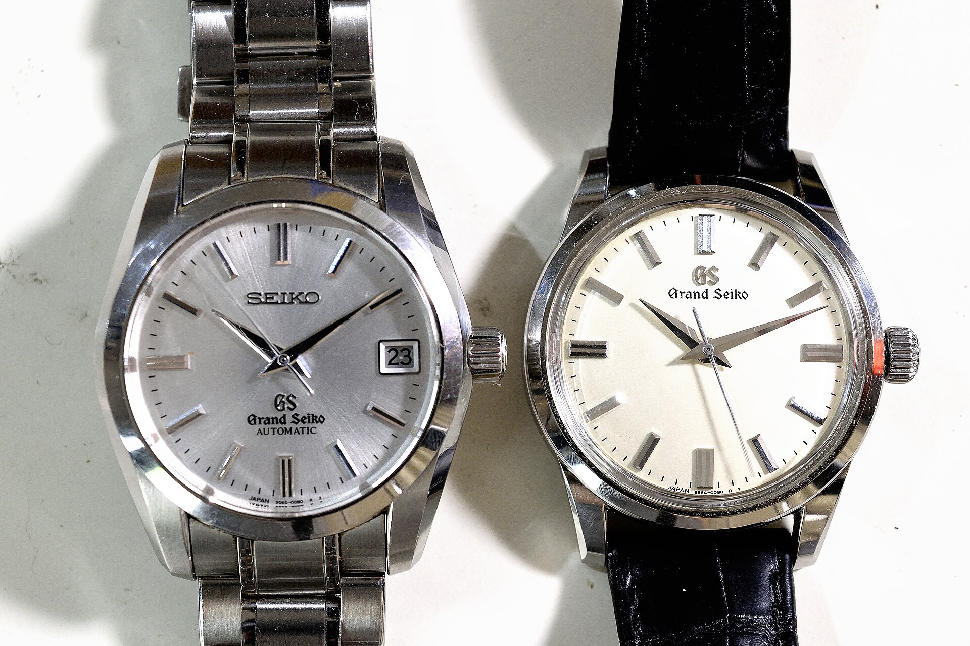 Two Grand Seiko watches side by side, one dial signed Seiko with GS below, the other signed only Grand Seiko