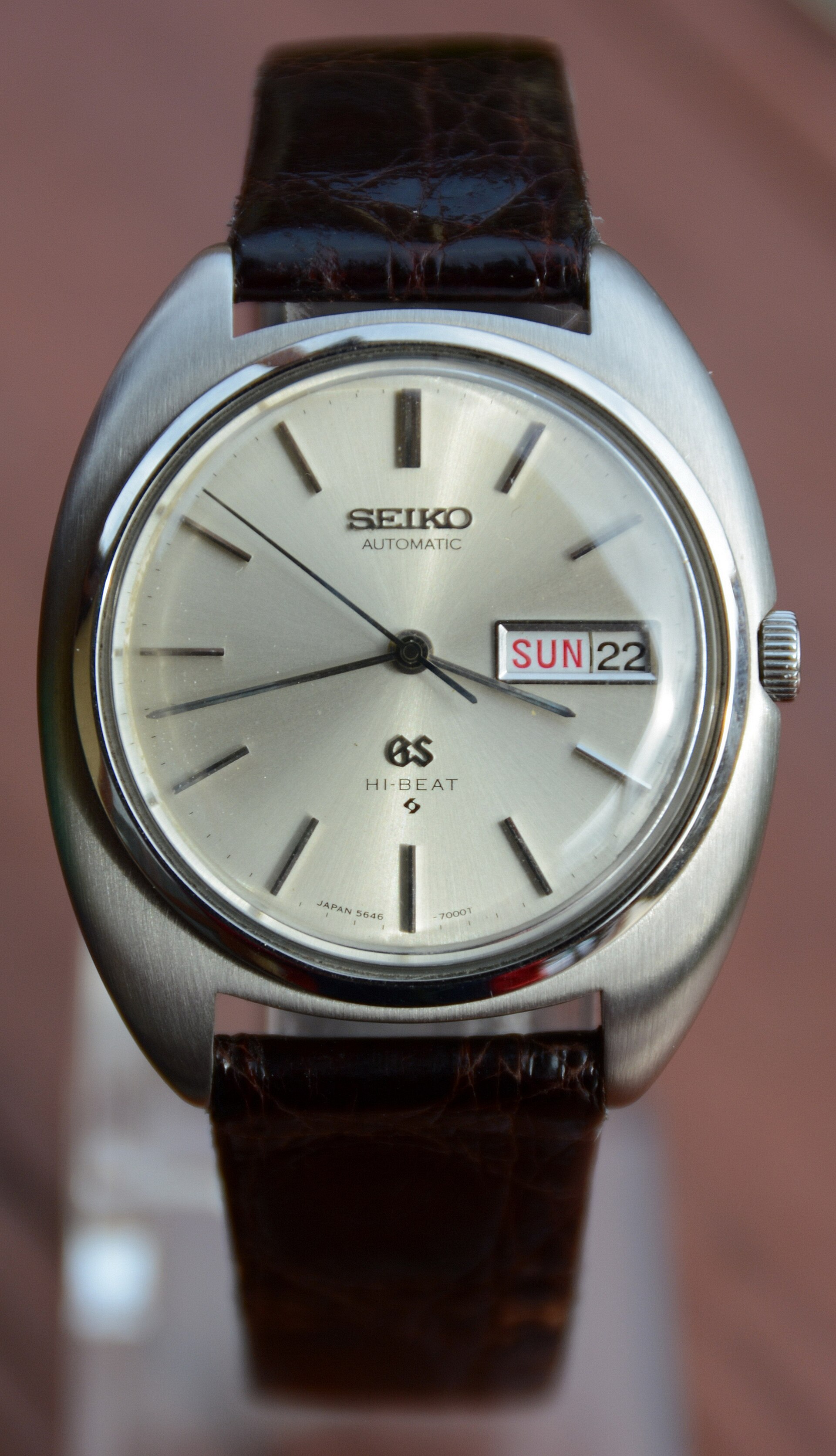 A vintage Grand Seiko Automatic Hi-Beat with a silver dial and day-date window on a brown leather strap