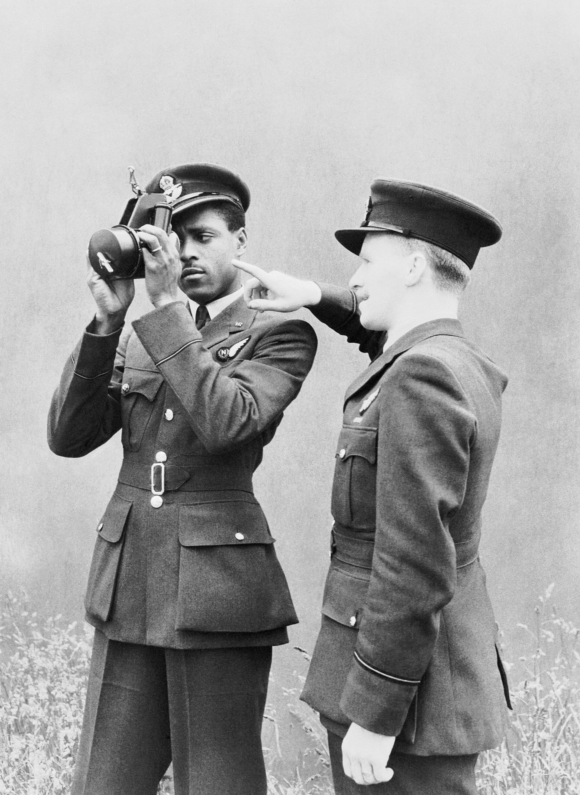 Pilot Officer J H Smythe of Sierra Leone, a newly-qualified navigator, being instructed in the use of the sextant by an instructor at No. 11 Operational Training Unit, Westcott in Buckinghamshire, 1 August 1943. Pilot Officer J H Smythe RAFVR of Sierra Leone, a newly-qualified navigator, being instructed in the use of the sextant by a flying officer instructor at No 11 Operational Training Unit, Westcott, Buckinghamshire, England.