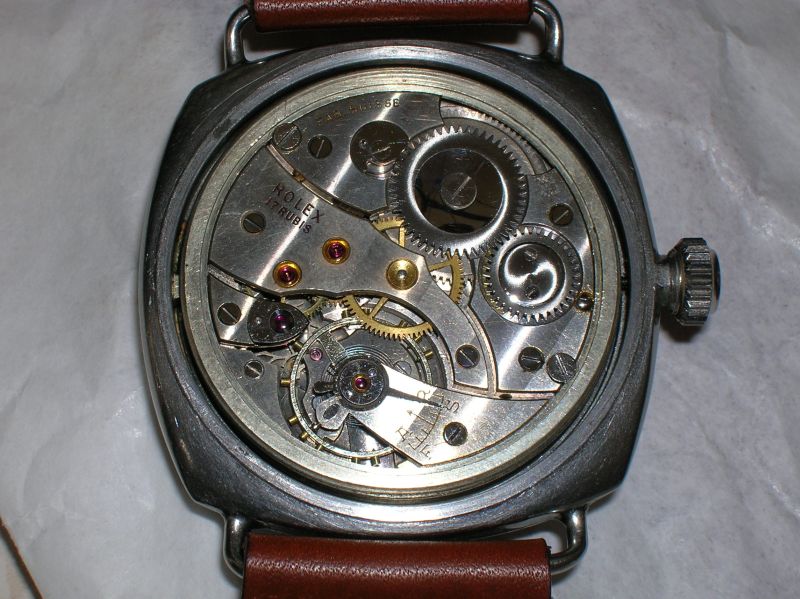The open case back of a Panerai 3646 showing its Rolex movement, on a brown strap