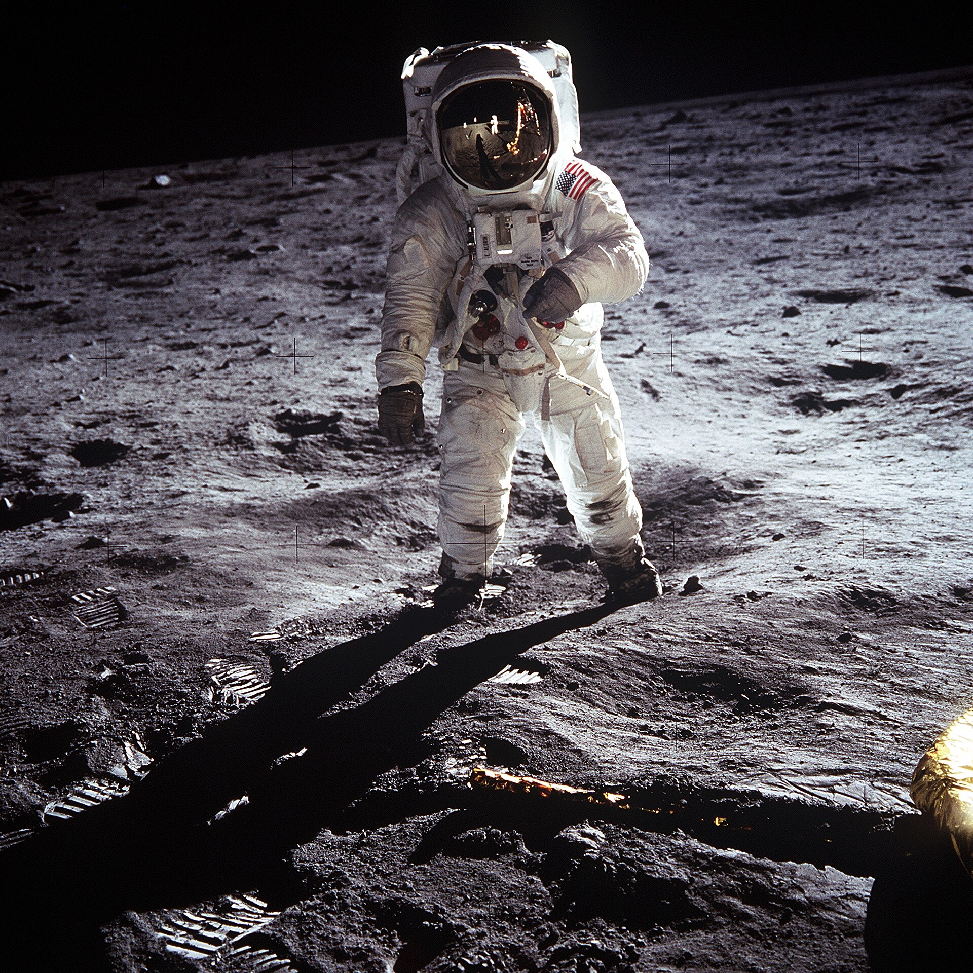 Short description : Astronaut Buzz Aldrin on the Moon Full description : Astronaut Buzz Aldrin , Lunar Module pilot, walks on the surface of the Moon near the leg of the Lunar Module (LM) "Eagle" during the Apollo 11 extravehicular activity (EVA). Astronaut Neil A. Armstrong , commander, took this photograph with a 70mm lunar surface camera. While astronauts Armstrong and Aldrin descended in the Lunar Module (LM) "Eagle" to explore the Sea of Tranquility region of the Moon, astronaut Michael Collins, command module pilot, remained with the Command and Service Modules (CSM) "Columbia" in lunar orbit. Variations : The upper black band is an addition to the original photo, carried out for "reasons of balance". See the original photo and the explanation of the edit at NASA's website . In the expanded version of the photo, it is possible to see a horizontal white line at the top left (viewer's right) of the helmet. This is the base of the antenna that was cut in the original frame of the photo.