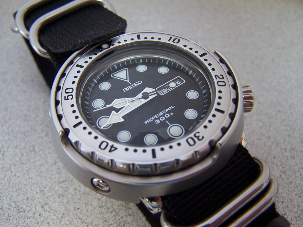 A shrouded Seiko Professional 300 m Tuna diver on a black NATO strap