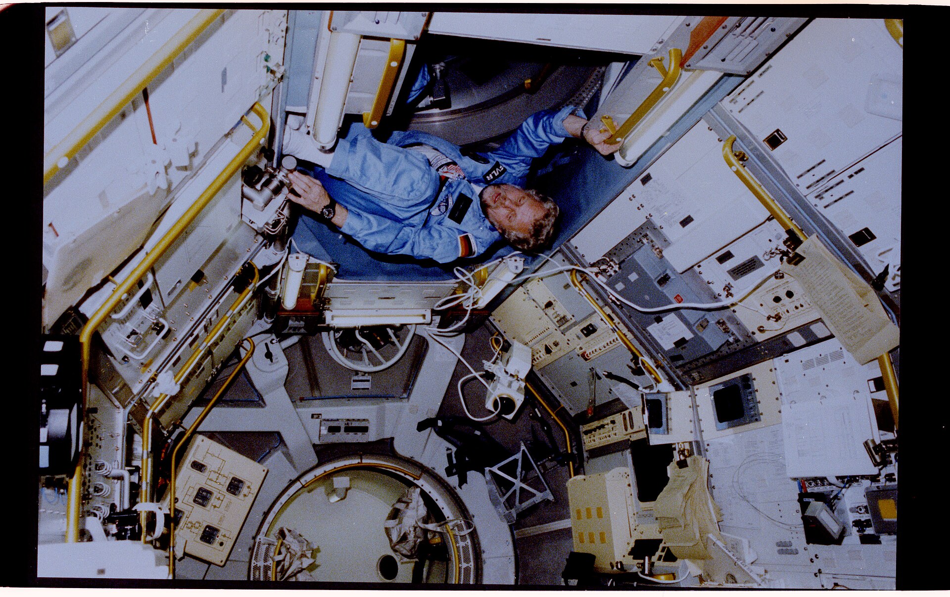 Reinhard Furrer floating inside the Spacelab D1 module during STS-61-A with a watch on his wrist