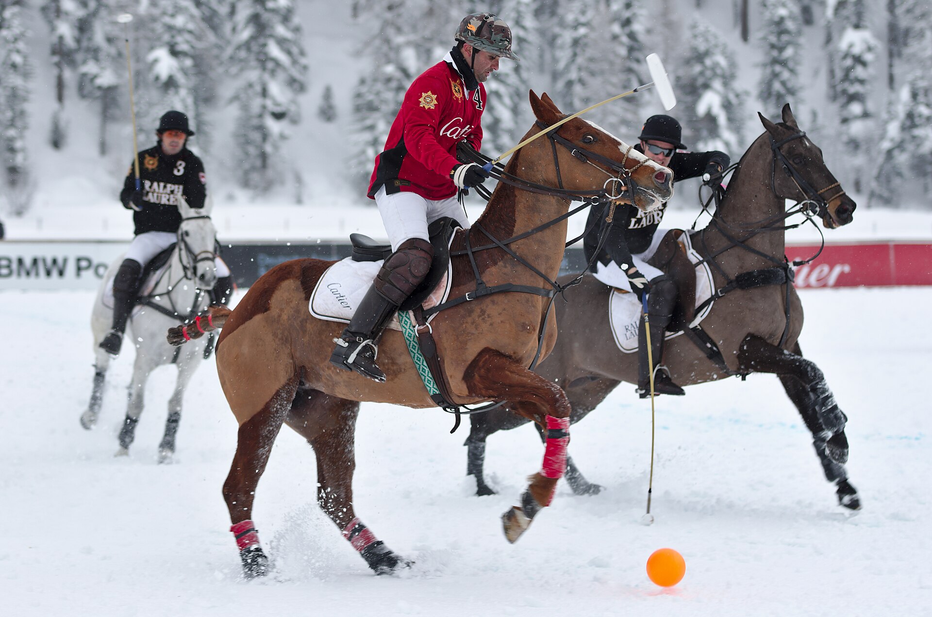 Polo players on horseback competing on snow at the St. Moritz Polo World Cup