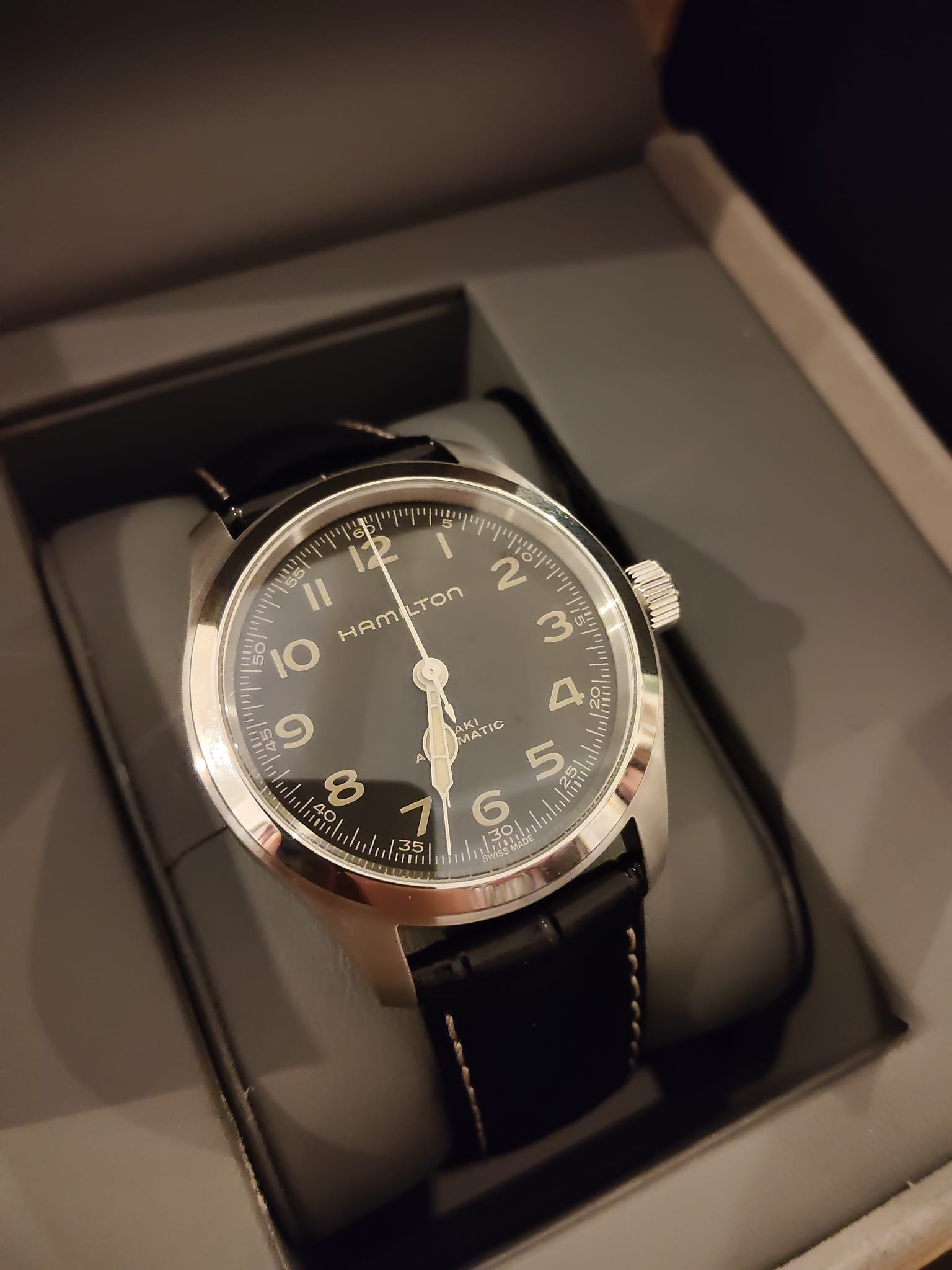 A Hamilton Khaki Field Murph with a black dial sitting in its presentation box