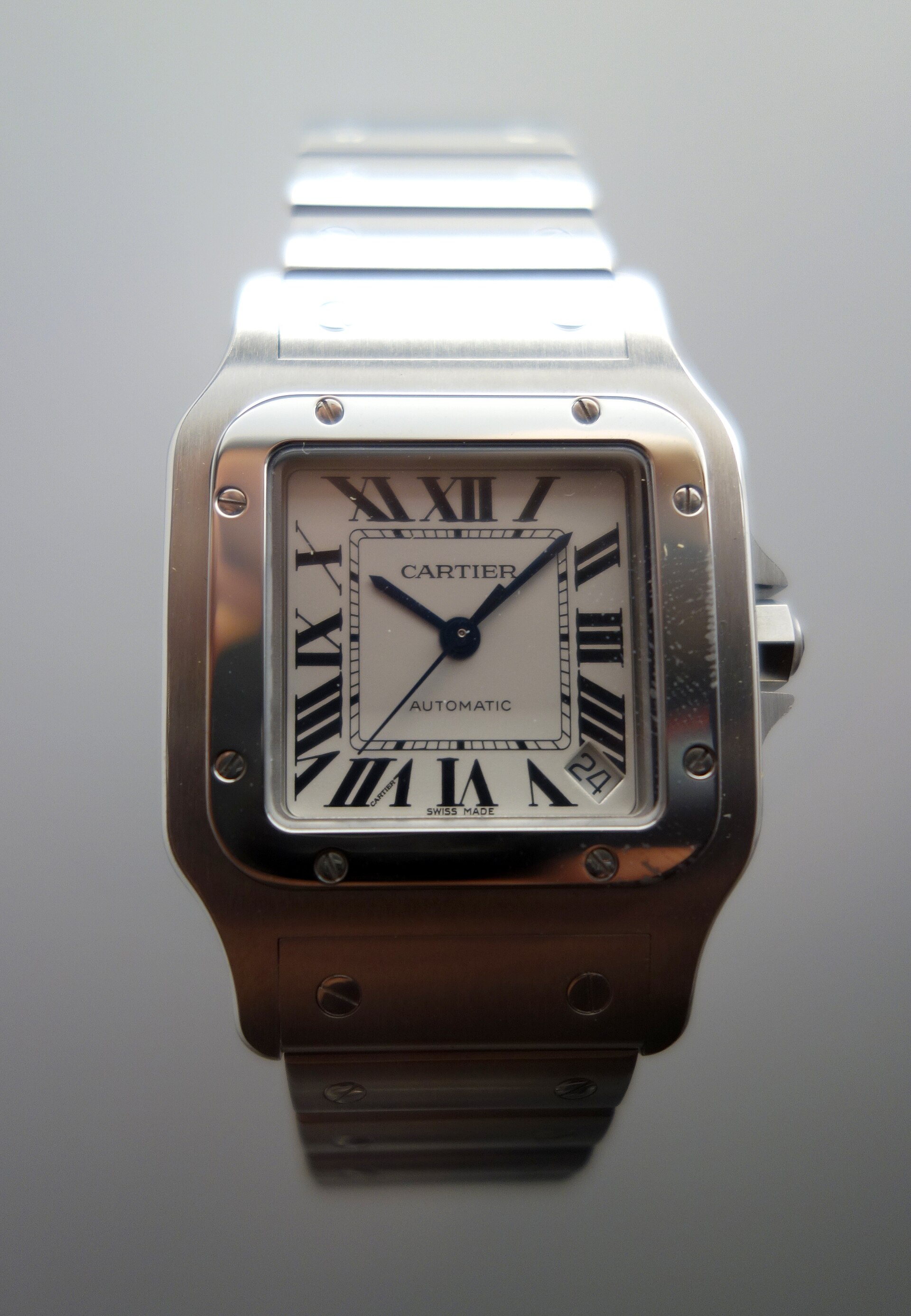 A steel Santos de Cartier Galbee with a white Roman-numeral dial on a museum stand